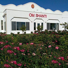 A white building bearing the words Om Shanti in red.