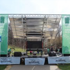 Outdoor music stage with green banners on the right and left-hand sides.